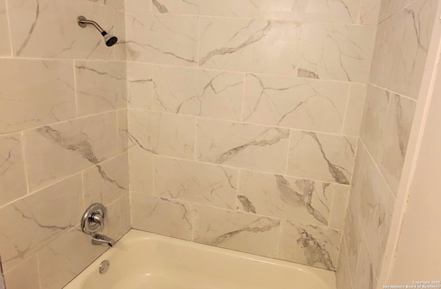 bathroom featuring tiled shower / bath