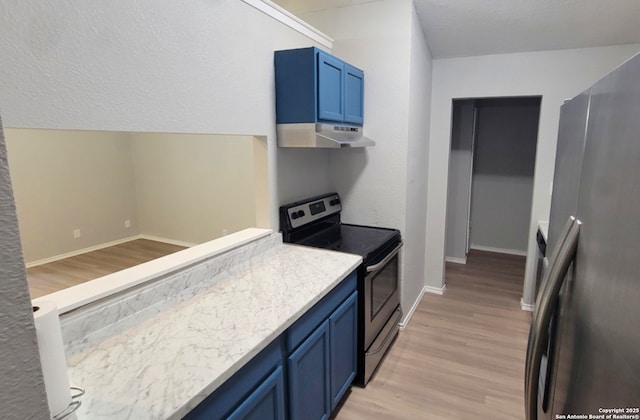 kitchen with blue cabinetry, stainless steel appliances, and light hardwood / wood-style flooring