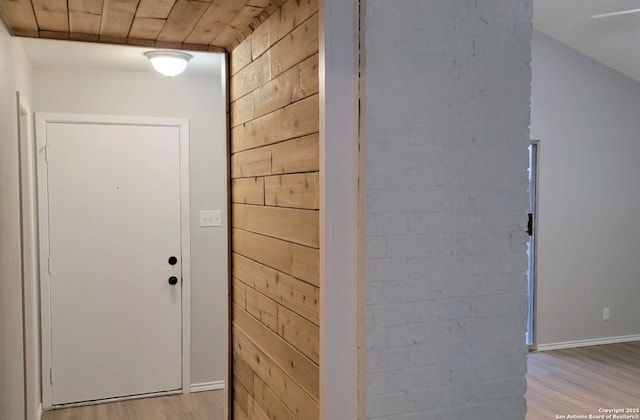 interior space with light hardwood / wood-style flooring and wood walls