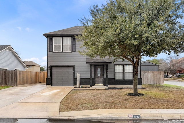 traditional-style home featuring a garage, concrete driveway, brick siding, and fence