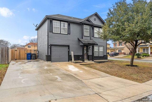 traditional-style house featuring fence, driveway, and an attached garage