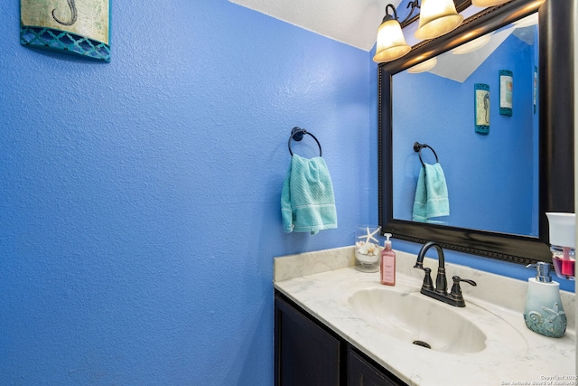 bathroom with a textured wall and vanity