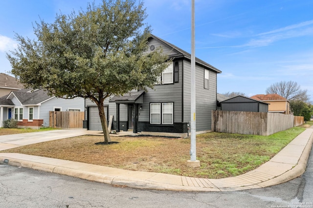 traditional-style house featuring driveway, fence, and a front yard