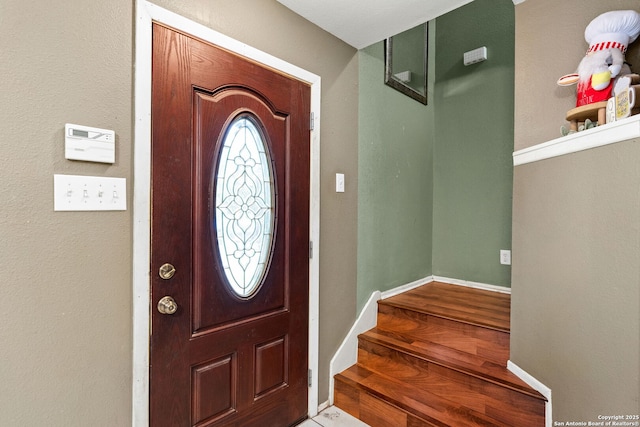 entrance foyer with stairway, baseboards, and wood finished floors