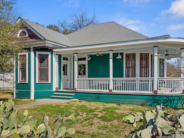 view of front facade with covered porch, a shingled roof, and a ceiling fan