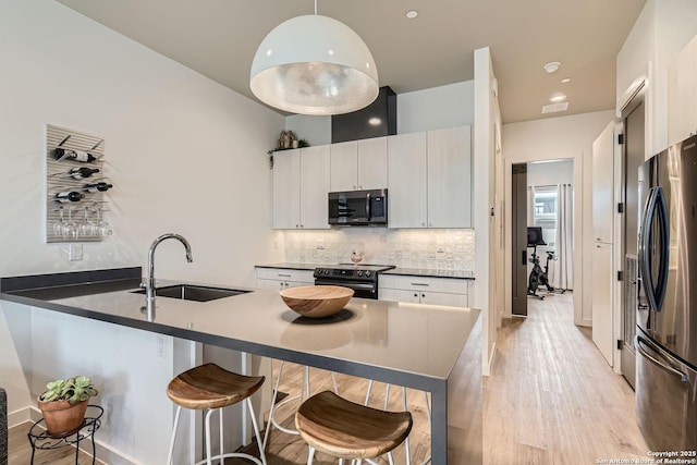 kitchen featuring stainless steel appliances, sink, hanging light fixtures, and white cabinets