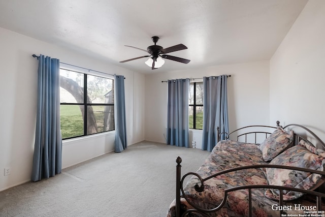 carpeted bedroom with multiple windows and ceiling fan