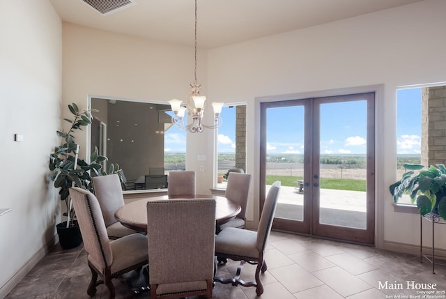 dining area with french doors and a chandelier