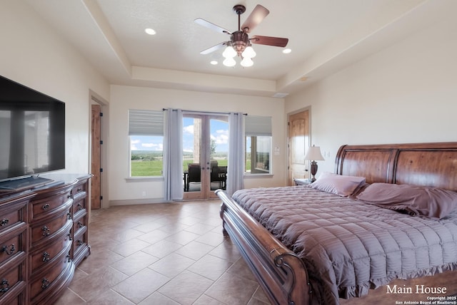 tiled bedroom featuring access to exterior, a raised ceiling, ceiling fan, and french doors