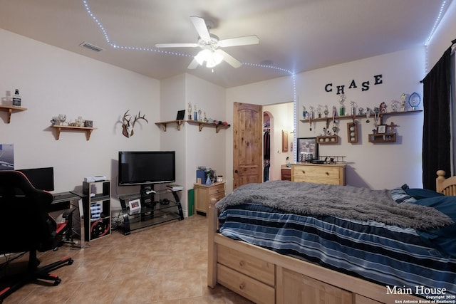 bedroom with light tile patterned floors, a spacious closet, and ceiling fan