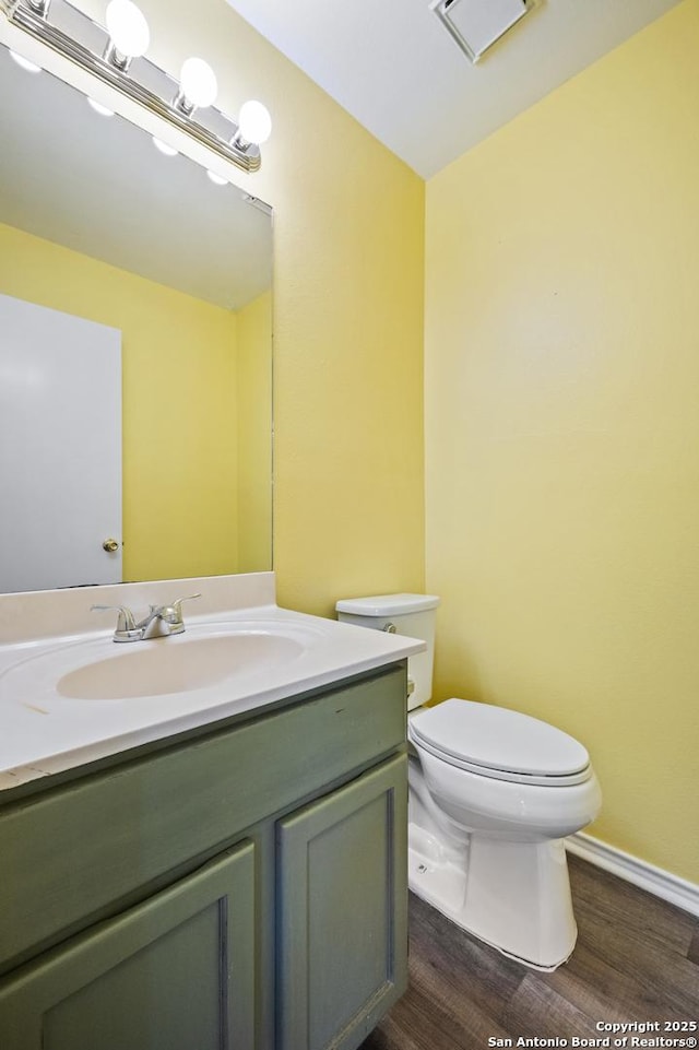 bathroom with vanity, toilet, and hardwood / wood-style floors