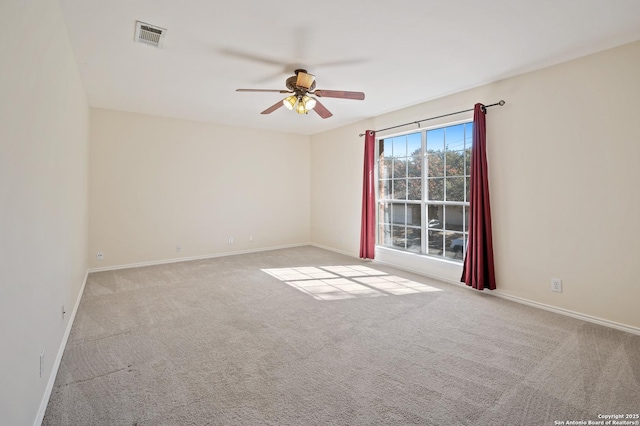 empty room with ceiling fan and light carpet