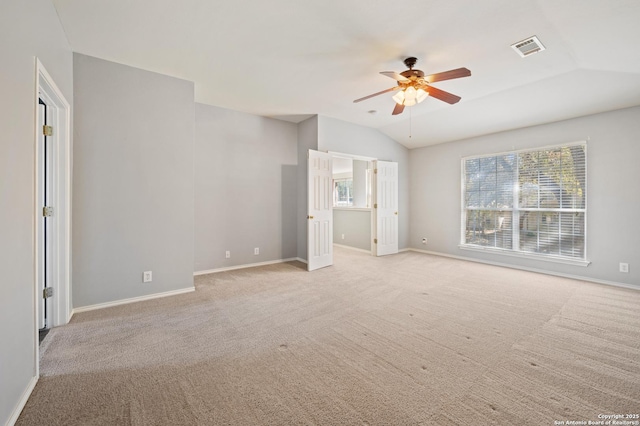 interior space with vaulted ceiling, a healthy amount of sunlight, and light colored carpet