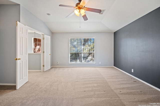 carpeted empty room featuring vaulted ceiling and ceiling fan