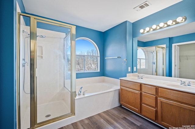 bathroom featuring plenty of natural light, shower with separate bathtub, and hardwood / wood-style floors