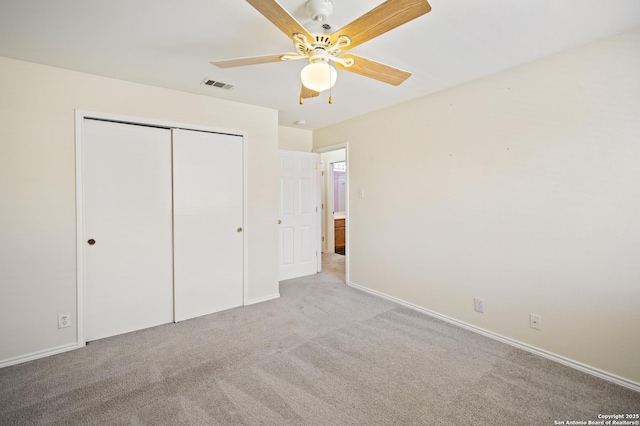 unfurnished bedroom featuring light colored carpet, ceiling fan, and a closet