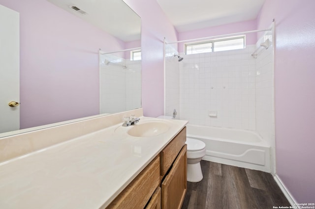 full bathroom with vanity, tiled shower / bath combo, wood-type flooring, and toilet