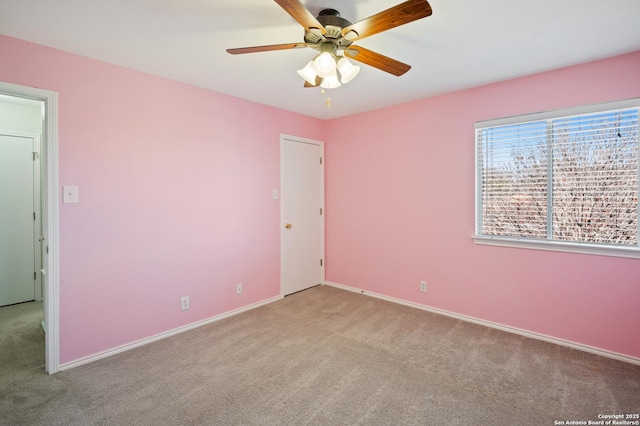 carpeted spare room featuring ceiling fan