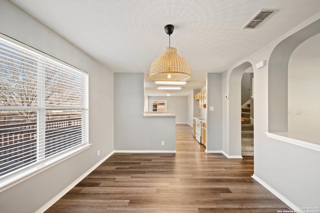 unfurnished dining area with dark hardwood / wood-style flooring and a wealth of natural light