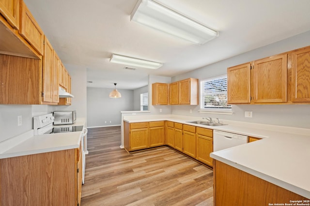 kitchen featuring sink, hanging light fixtures, light wood-type flooring, kitchen peninsula, and white appliances