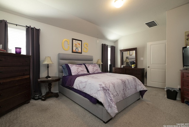 bedroom featuring light colored carpet and vaulted ceiling