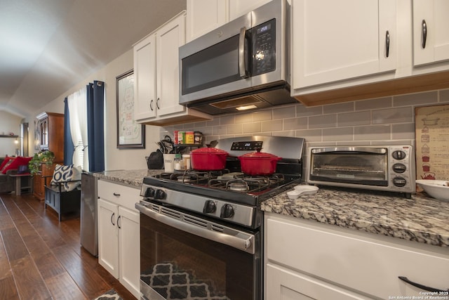 kitchen with appliances with stainless steel finishes, backsplash, dark hardwood / wood-style floors, light stone counters, and white cabinets