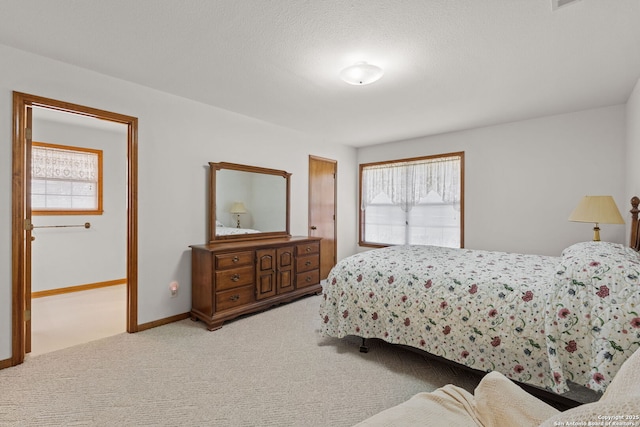 bedroom with light carpet and a textured ceiling