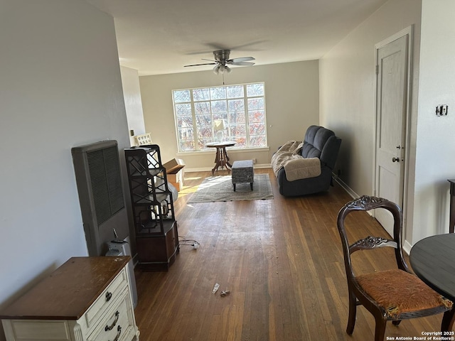 sitting room with dark wood-type flooring and ceiling fan