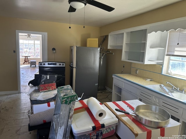 kitchen featuring sink, white cabinetry, stainless steel appliances, tile counters, and decorative backsplash