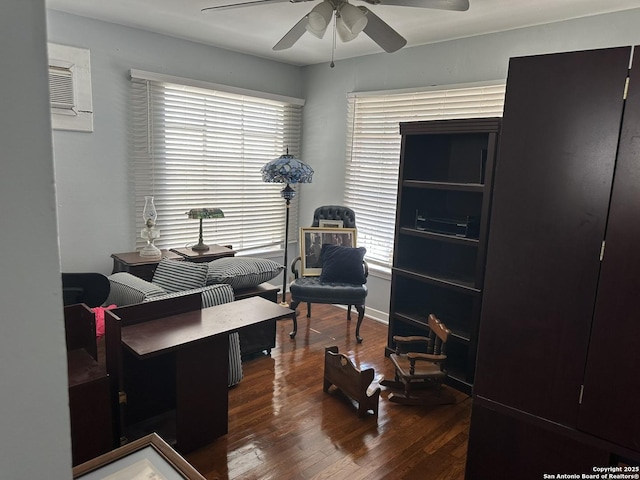 home office with dark wood-type flooring, an AC wall unit, and ceiling fan