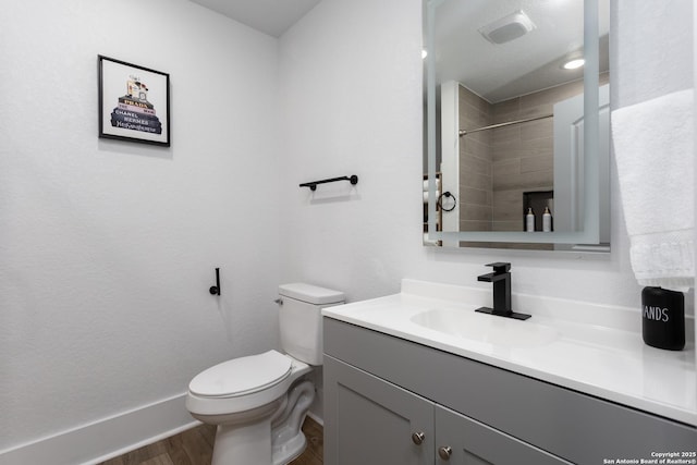 bathroom with vanity, wood-type flooring, walk in shower, and toilet