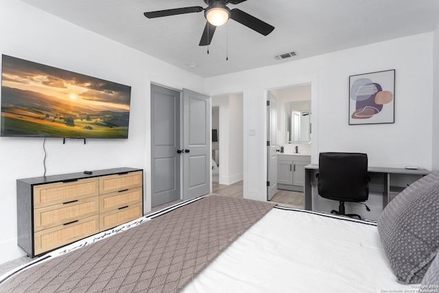 bedroom featuring ceiling fan, light wood-type flooring, sink, and ensuite bath