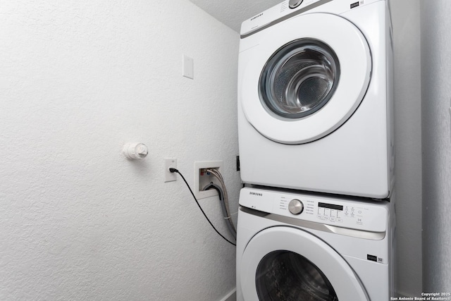 clothes washing area featuring stacked washer / dryer