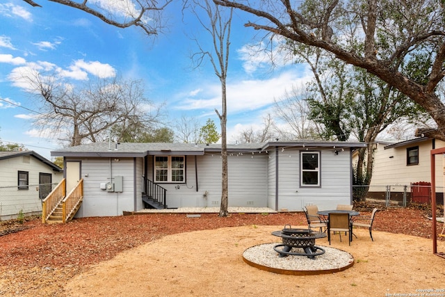 back of property with an outdoor fire pit