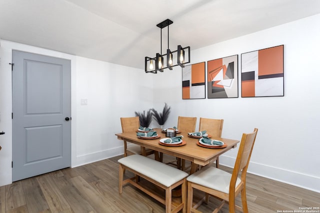 dining area featuring a notable chandelier and hardwood / wood-style flooring