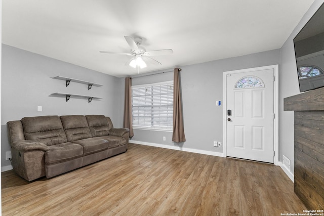 living room with light hardwood / wood-style flooring and ceiling fan