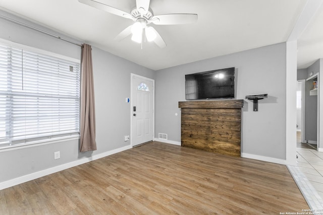 unfurnished living room featuring ceiling fan and light hardwood / wood-style flooring