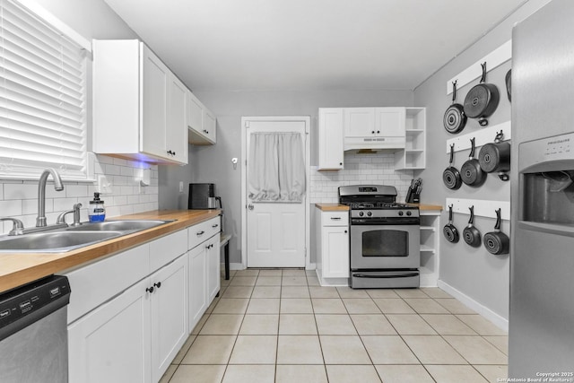 kitchen with appliances with stainless steel finishes, sink, wooden counters, and white cabinets