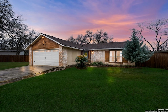 ranch-style house featuring a garage and a yard