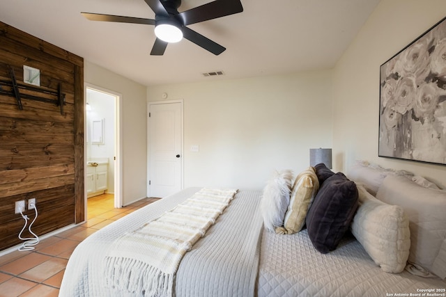 tiled bedroom with connected bathroom and ceiling fan