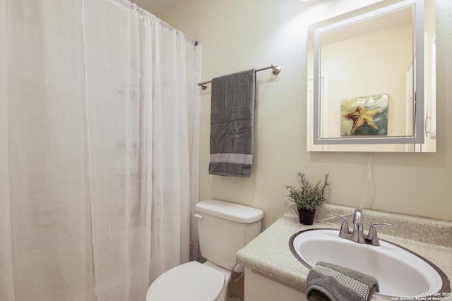 bathroom featuring vanity, walk in shower, and toilet