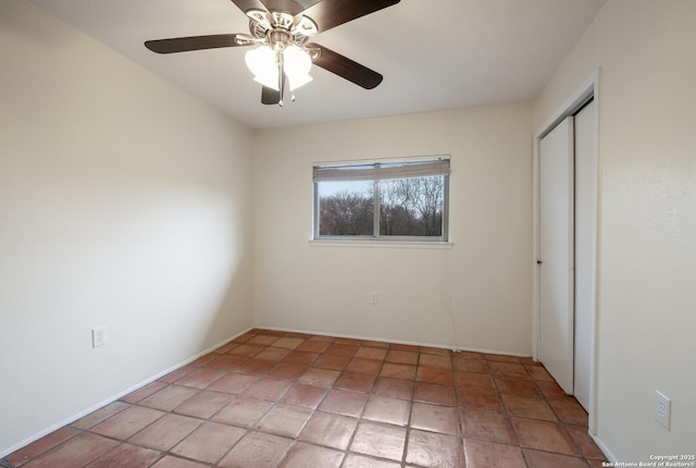 interior space with ceiling fan and a closet