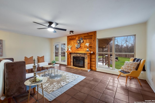 living room featuring a brick fireplace, french doors, and ceiling fan