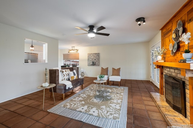 living room featuring ceiling fan and a fireplace