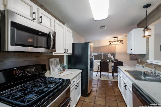 kitchen with sink, a textured ceiling, pendant lighting, stainless steel appliances, and white cabinets