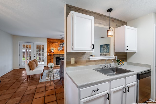 kitchen with french doors, sink, white cabinetry, stainless steel dishwasher, and pendant lighting