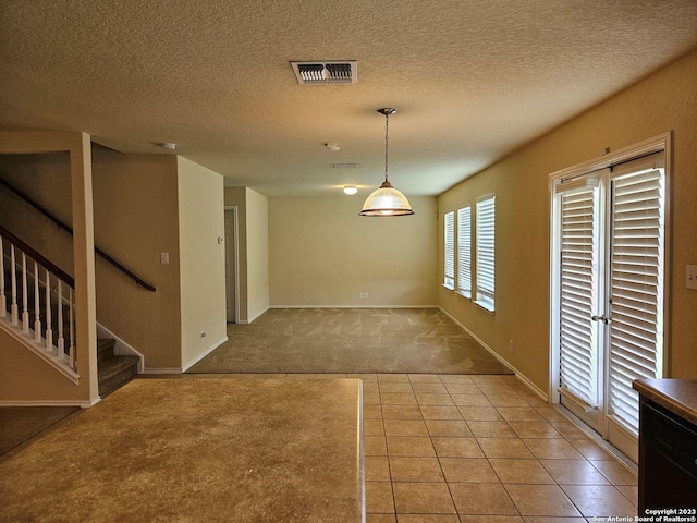 interior space featuring light colored carpet and a textured ceiling