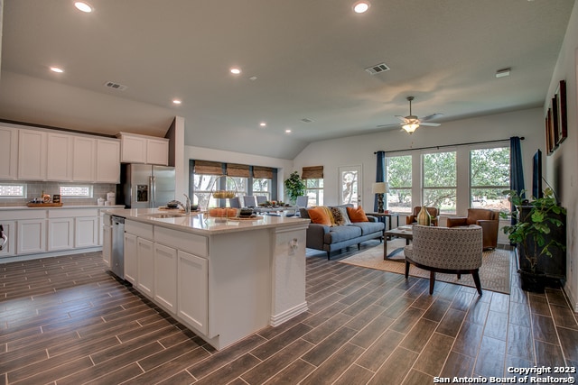 kitchen featuring sink, tasteful backsplash, an island with sink, stainless steel appliances, and white cabinets