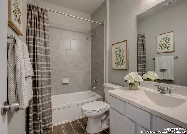 full bathroom with vanity, shower / bath combination with curtain, and toilet