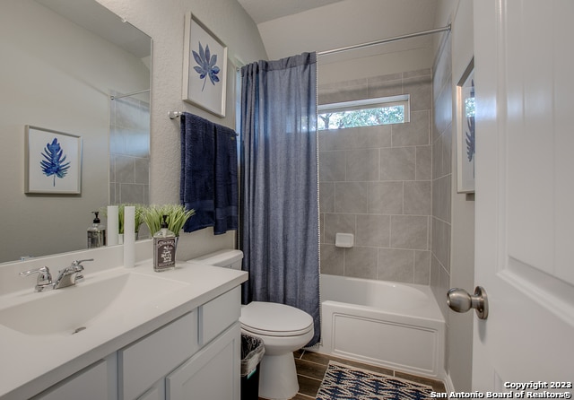 full bathroom with shower / tub combo, vanity, and toilet